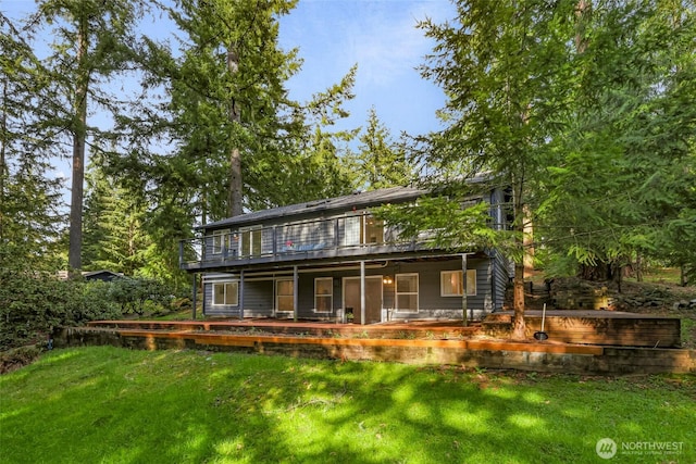 back of property with a wooden deck and a yard