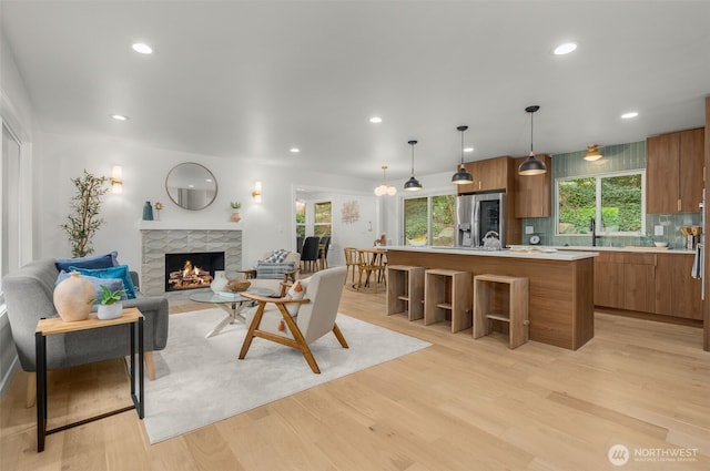 107 219th Pl SE, Bothell, WA 98021 - living area with light wood finished floors, a tiled fireplace, recessed lighting, and plenty of natural light