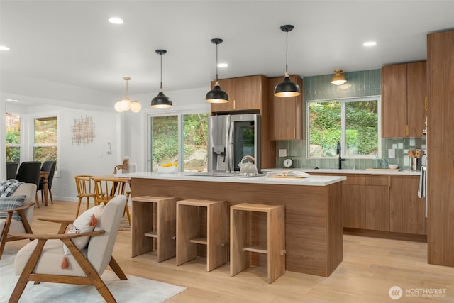 107 219th Pl SE, Bothell, WA 98021 - kitchen with light countertops, brown cabinets, tasteful backsplash, and stainless steel refrigerator with ice dispenser