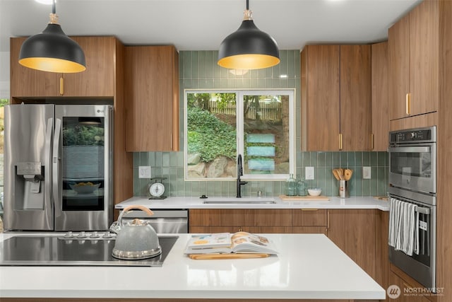 107 219th Pl SE, Bothell, WA 98021 - kitchen featuring light countertops, appliances with stainless steel finishes, brown cabinetry, and a sink
