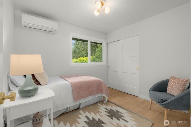 107 219th Pl SE, Bothell, WA 98021 - bedroom featuring a wall mounted AC, a closet, baseboards, and wood finished floors