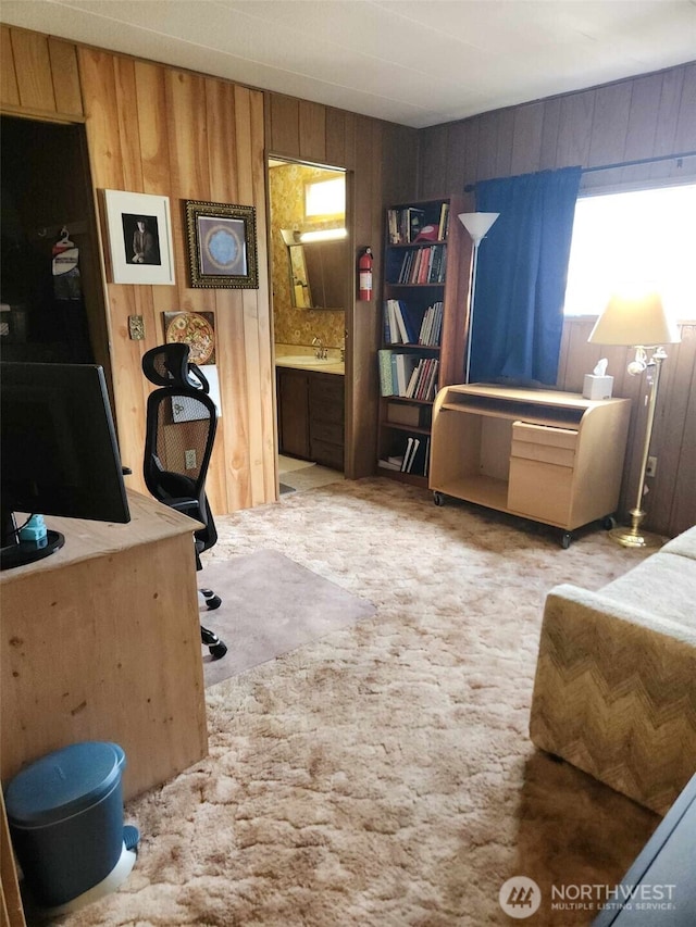 carpeted office with a sink and wood walls