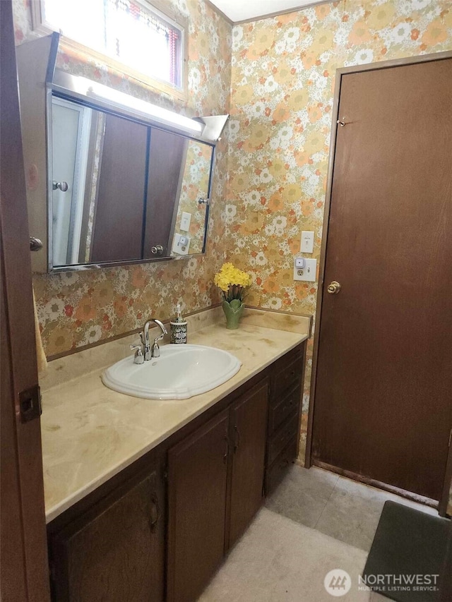 bathroom with tile patterned flooring, vanity, and wallpapered walls