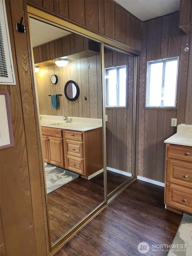 full bath featuring wooden walls, vanity, and wood finished floors