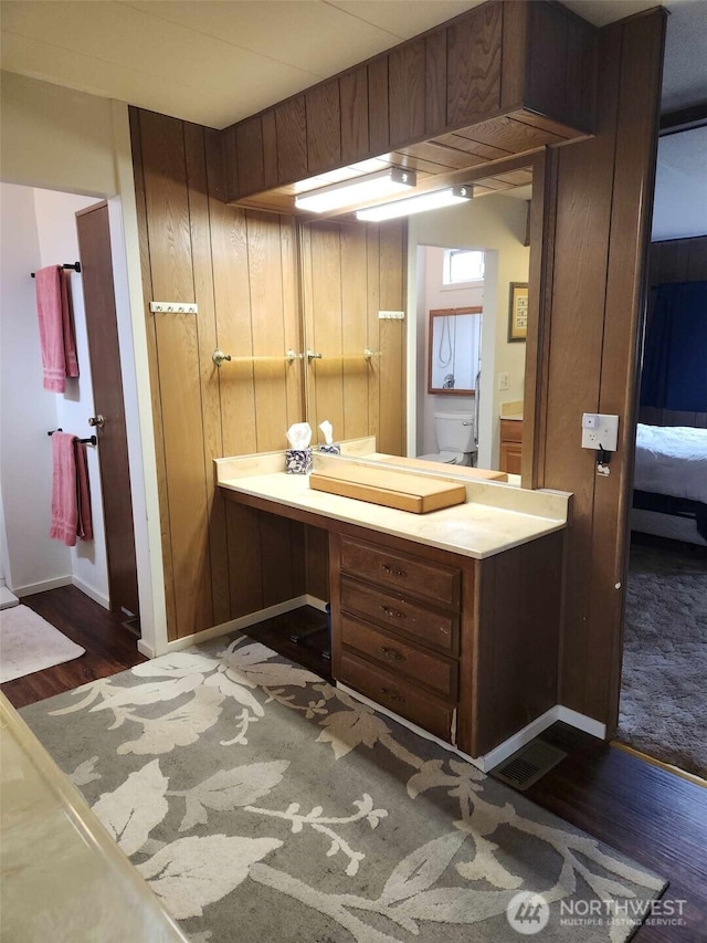bathroom featuring wood finished floors, vanity, and baseboards