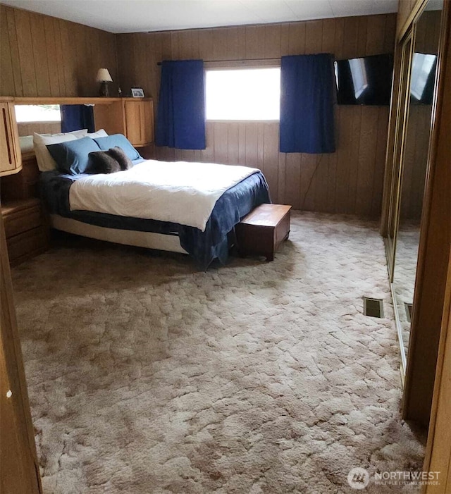 bedroom featuring wood walls, carpet, and visible vents