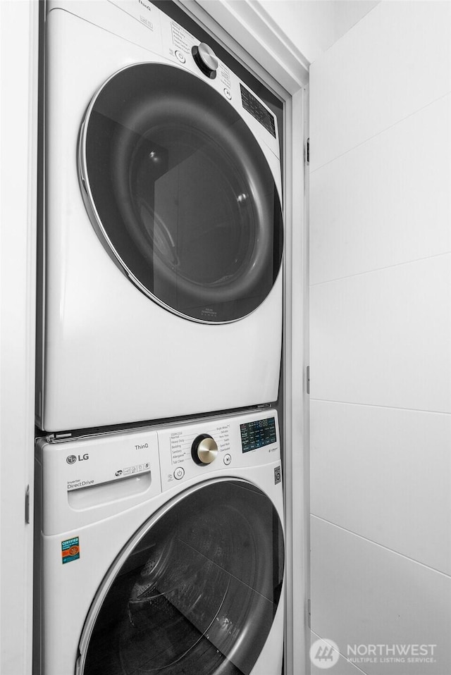 clothes washing area with stacked washer and clothes dryer