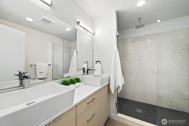 bathroom with visible vents, a sink, recessed lighting, and a marble finish shower