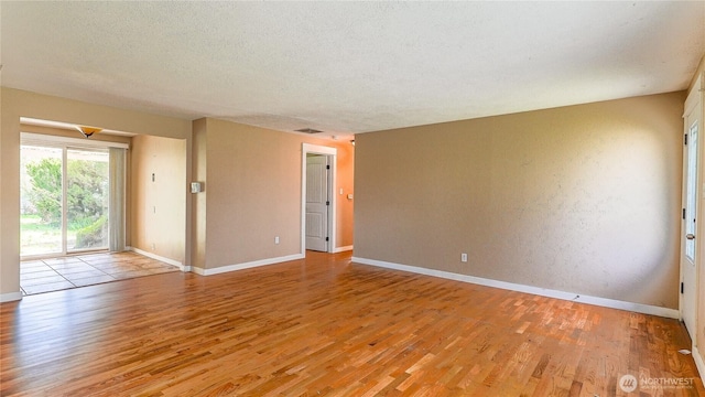 2125 N Highland St, Tacoma, WA 98406 - empty room with light wood-type flooring, baseboards, visible vents, and a textured ceiling
