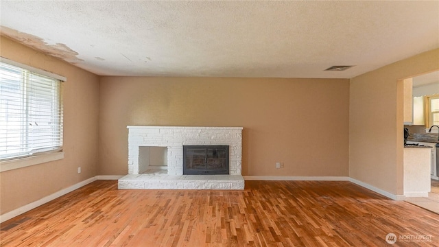 2125 N Highland St, Tacoma, WA 98406 - unfurnished living room with visible vents, baseboards, a textured ceiling, and light wood-style flooring