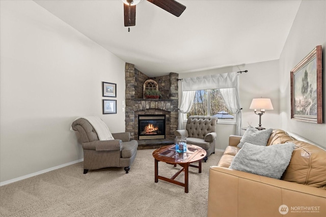 living room with vaulted ceiling, a ceiling fan, baseboards, a fireplace, and light colored carpet