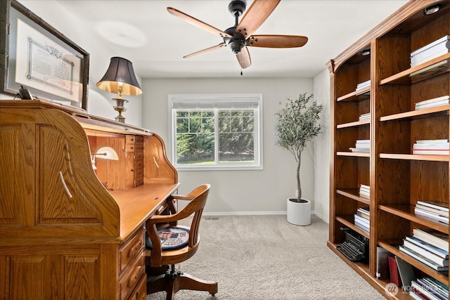 carpeted home office featuring baseboards and ceiling fan