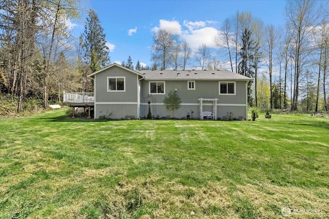 rear view of house with a wooden deck and a yard