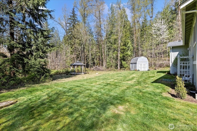 view of yard featuring an outdoor structure, a gazebo, and a shed