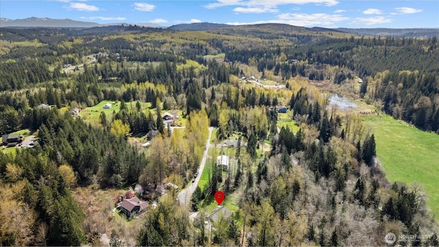 birds eye view of property featuring a mountain view and a wooded view