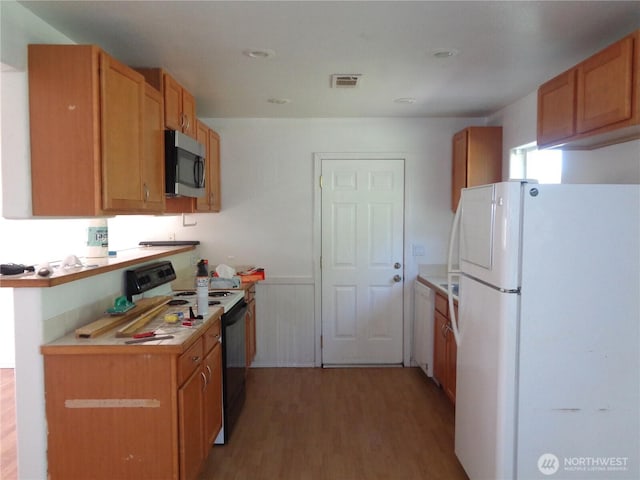 5 Orchard Loop N, Tonasket, WA 98855 - kitchen with light wood-style floors, electric range oven, freestanding refrigerator, stainless steel microwave, and visible vents