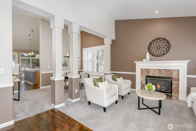 1231 148th Pl SE, Mill Creek, WA 98012 - living room with decorative columns, wood finished floors, a premium fireplace, vaulted ceiling, and baseboards