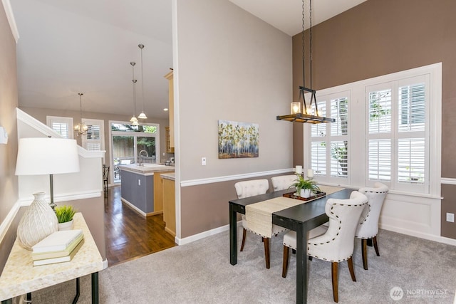 1231 148th Pl SE, Mill Creek, WA 98012 - dining room with a chandelier, high vaulted ceiling, dark carpet, plenty of natural light, and baseboards