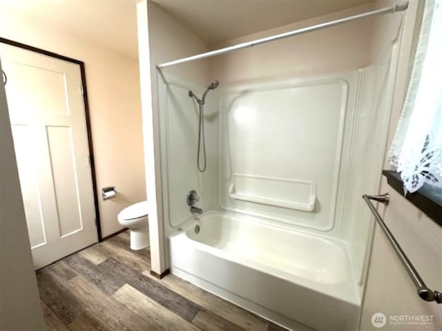 bathroom with shower / bath combination, wood finished floors, and toilet