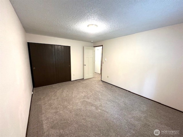unfurnished bedroom featuring carpet floors, a closet, and a textured ceiling