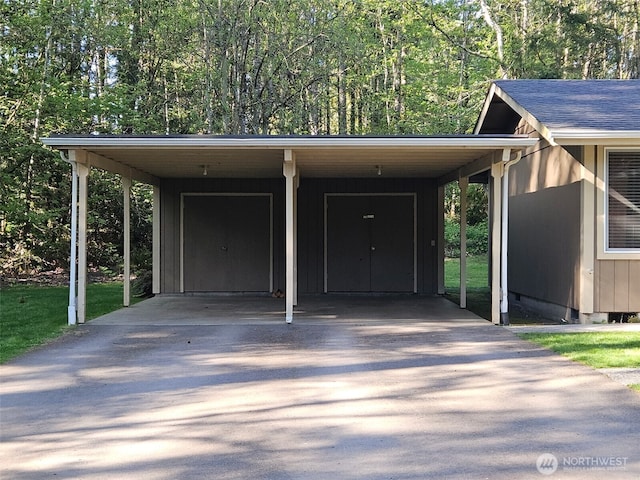 view of parking featuring concrete driveway and a carport