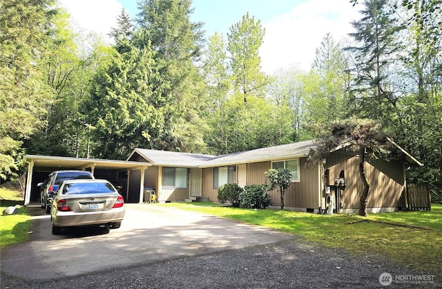 view of front of house with a front lawn, aphalt driveway, and a carport