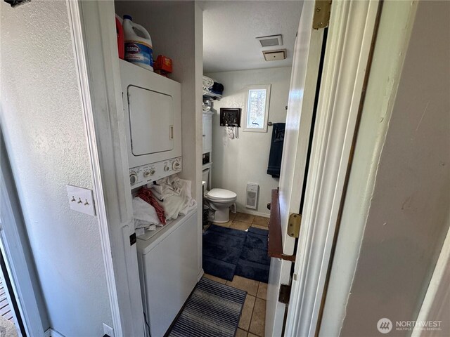 4751 State Route 109, Moclips, WA 98562 - bathroom featuring stacked washing machine and dryer, toilet, and tile patterned floors