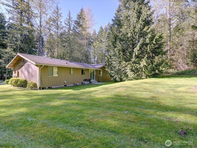 rear view of house featuring a lawn and entry steps