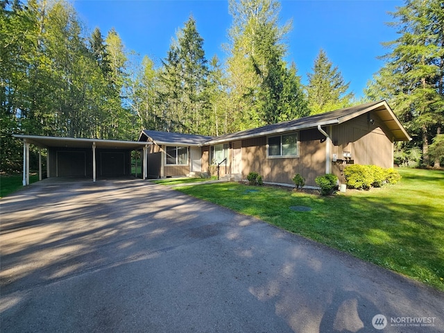 ranch-style home with an attached carport, driveway, and a front yard