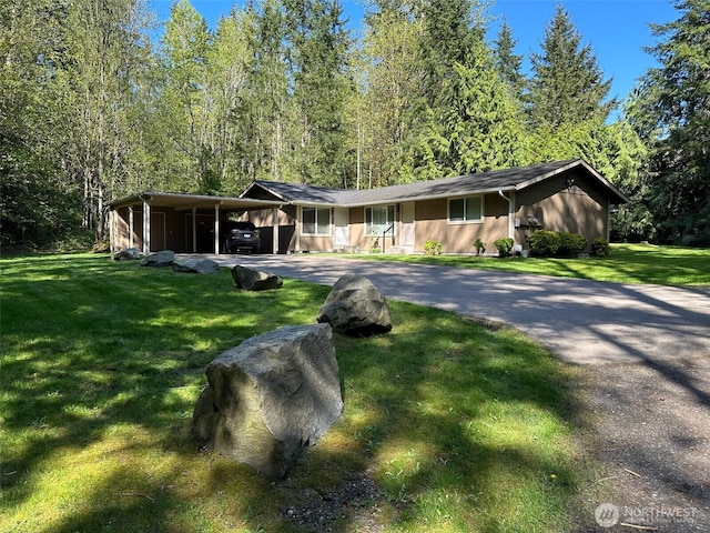 view of front of property with a front lawn, driveway, and a carport