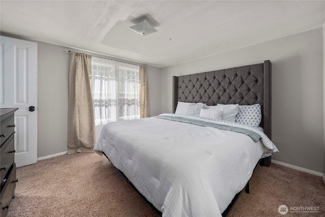 carpeted bedroom featuring baseboards, a textured wall, and a textured ceiling