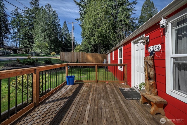 wooden deck with fence and a lawn