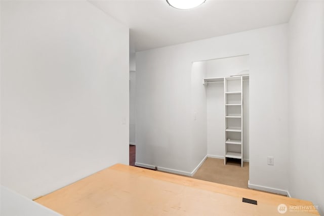 12334 31st Ave NE Unit 305, Seattle, WA 98125 - unfurnished bedroom with a closet, baseboards, and wood finished floors