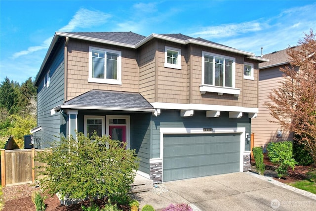 view of front of property with an attached garage, fence, a shingled roof, concrete driveway, and stone siding