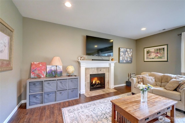living area featuring dark wood finished floors, a fireplace, baseboards, and recessed lighting