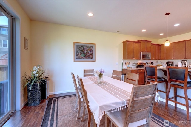 dining space featuring dark wood finished floors, recessed lighting, a fireplace, and baseboards