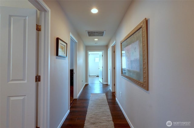 hall featuring dark wood finished floors, baseboards, and recessed lighting
