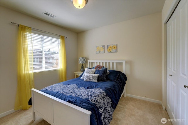 carpeted bedroom featuring a closet and baseboards