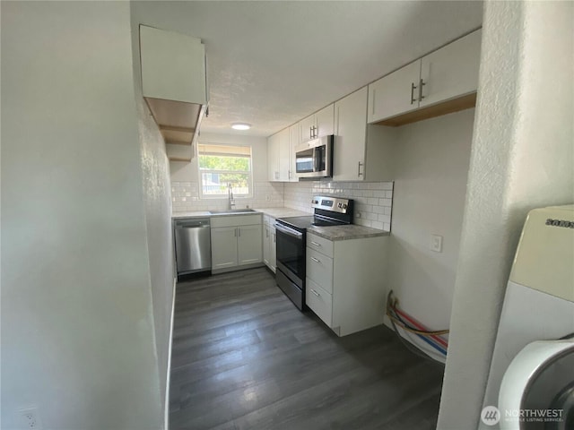 105 E 13th Ave, Kennewick, WA 99337 - kitchen with stainless steel appliances, decorative backsplash, dark wood-style flooring, white cabinets, and washer / clothes dryer