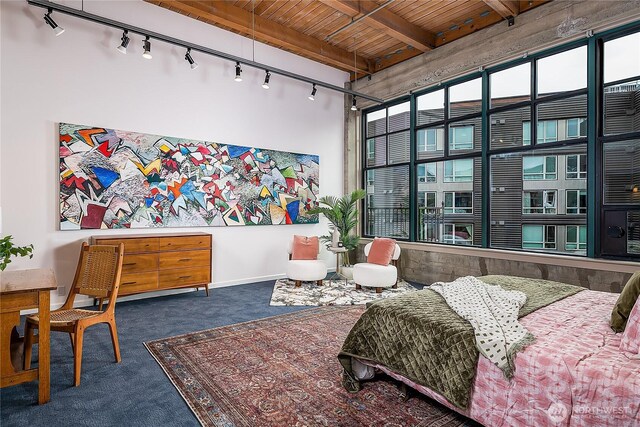bedroom with a high ceiling, wood ceiling, beam ceiling, carpet floors, and rail lighting