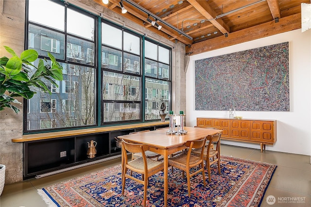 dining room featuring beamed ceiling, wooden ceiling, and track lighting