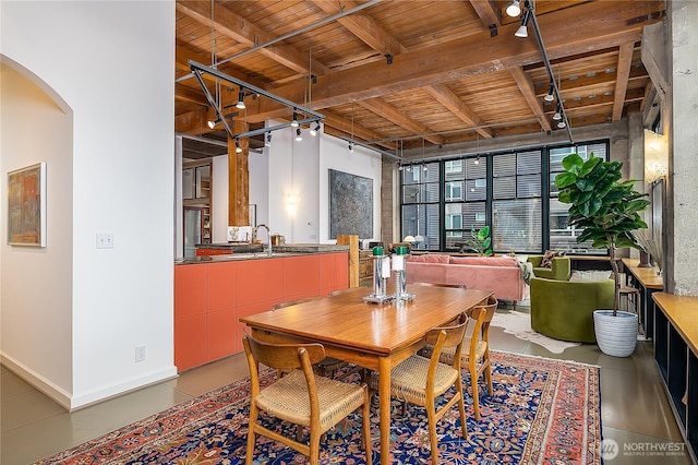 dining room featuring wooden ceiling, beamed ceiling, baseboards, and rail lighting