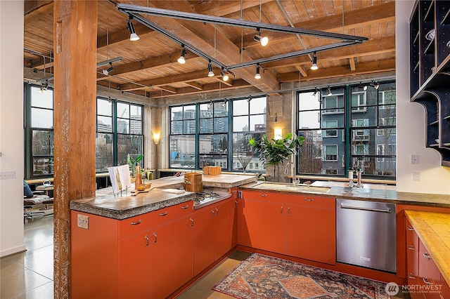 kitchen with a sink, stainless steel dishwasher, red cabinetry, and wood ceiling