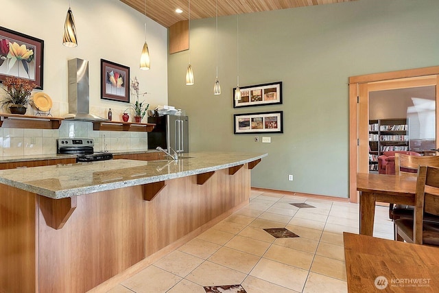 500 Darby Dr Unit A-304, Bellingham, WA 98226 - kitchen with appliances with stainless steel finishes, light tile patterned floors, wall chimney range hood, and a breakfast bar