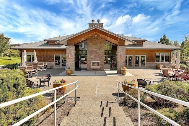 500 Darby Dr Unit A-304, Bellingham, WA 98226 - back of house featuring a patio area, stone siding, a fireplace, a chimney, and french doors