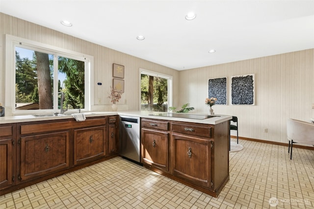 9376 Mercerwood Dr, Mercer Island, WA 98040 - kitchen featuring stainless steel dishwasher, a sink, black electric stovetop, light countertops, and brick patterned floor