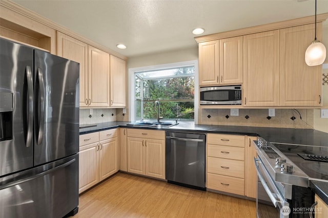 kitchen with a sink, appliances with stainless steel finishes, and light brown cabinets