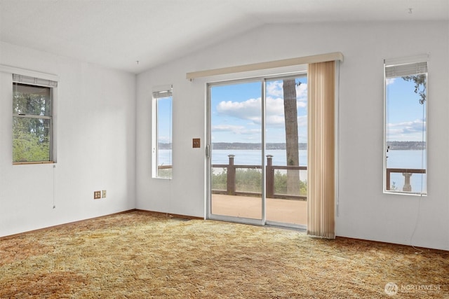 carpeted spare room with lofted ceiling and a water view