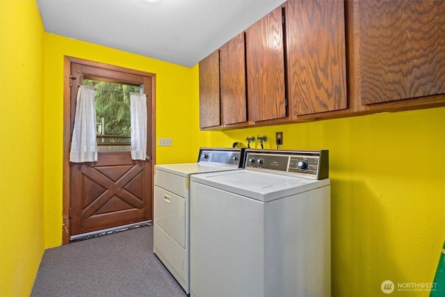 clothes washing area featuring washing machine and clothes dryer, carpet, and cabinet space