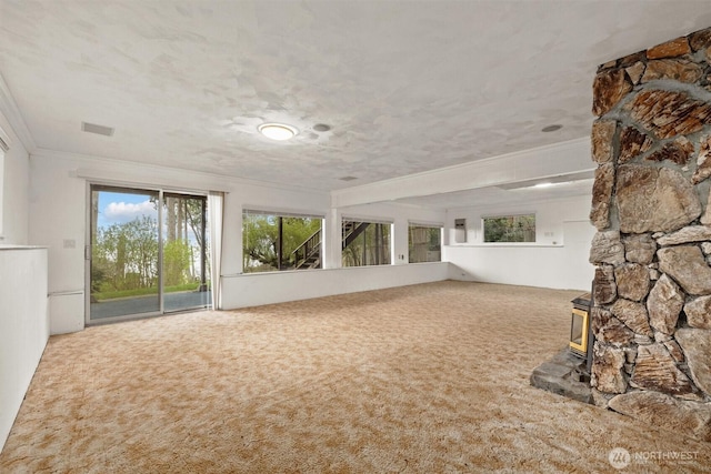 unfurnished sunroom featuring a wood stove and visible vents